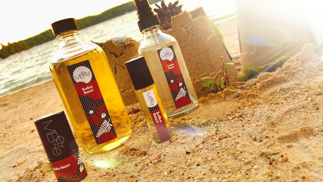 MBeze Koko Haze Collection including Deodorette, Body Oil, Perfume, and Body Mist on the sandy beach in Elkhart Lake, Wisconsin.