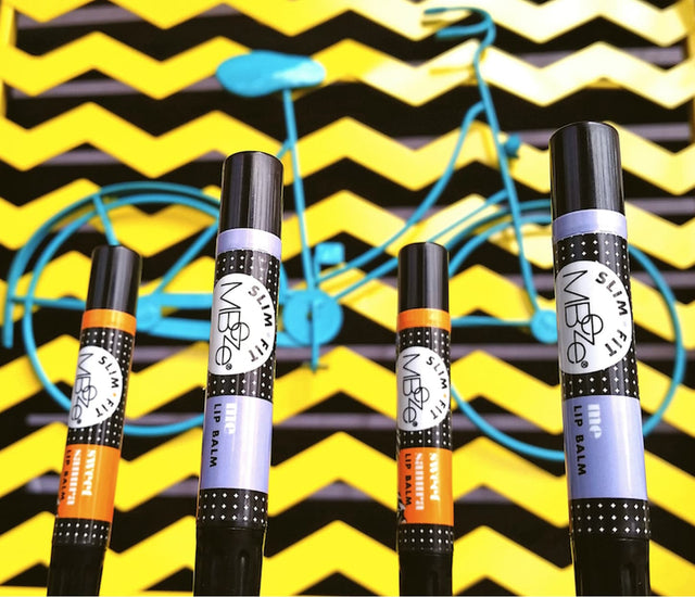 Orange Silk and Me MBeze Slim Fit Lip Balms with bike in backround.